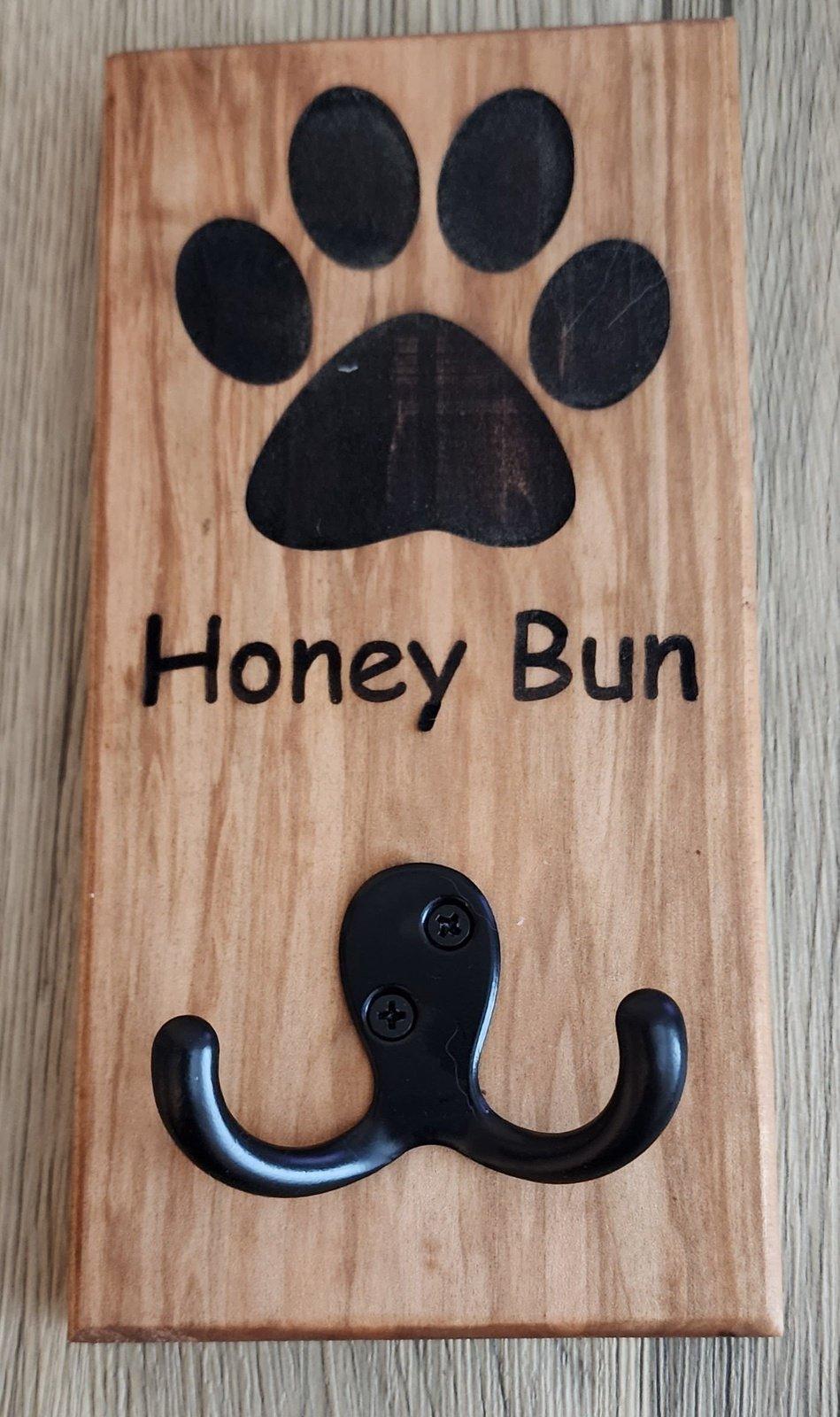 Custom white oak leash holder engraved with dog paw print and name Honey Bun