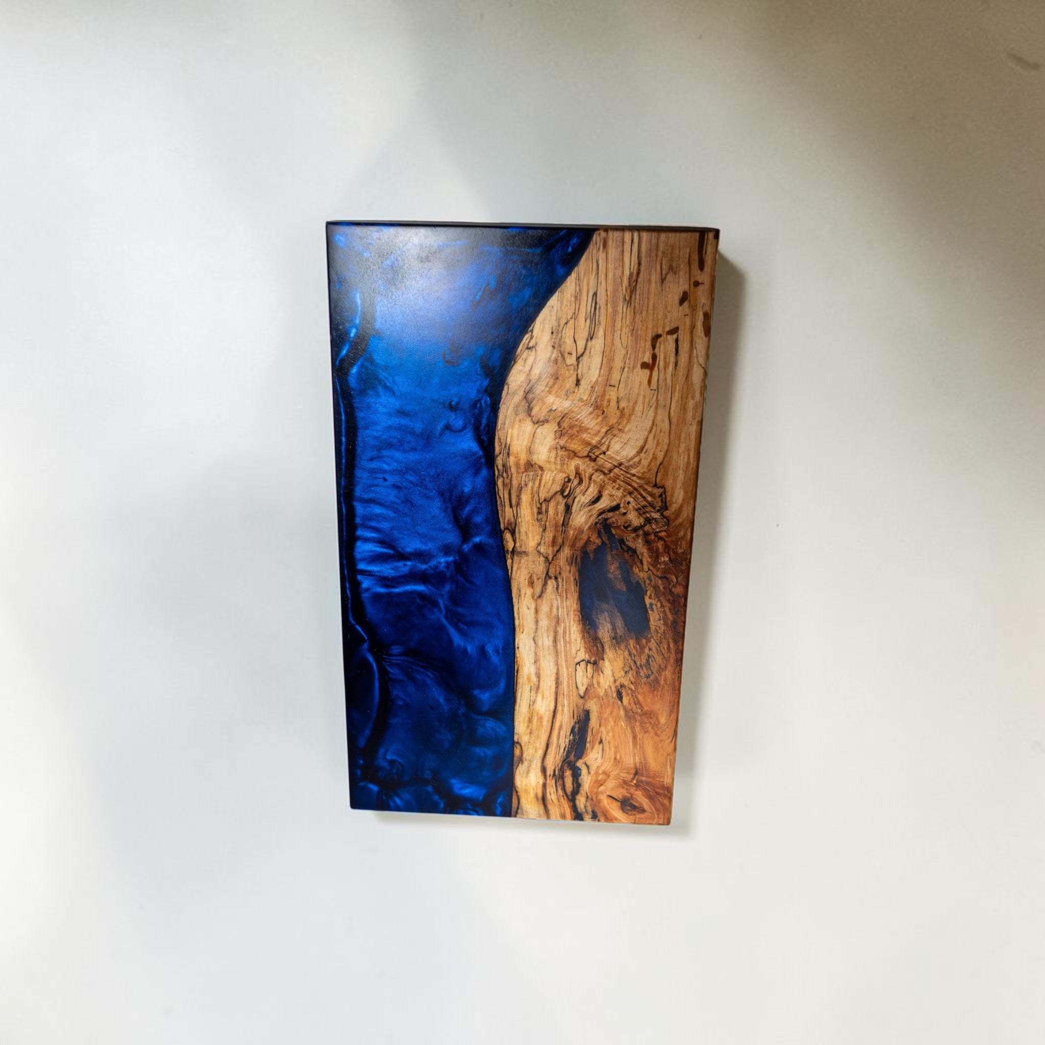 Handmade dark blue epoxy and maple wood serving board with marbled texture