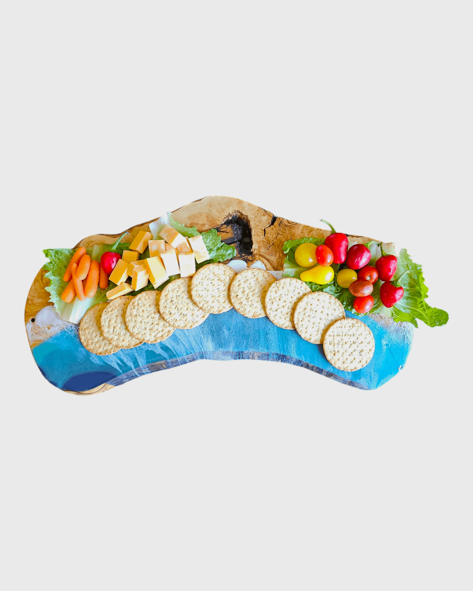 Oval olive wood charcuterie board styled with cheese and crackers
