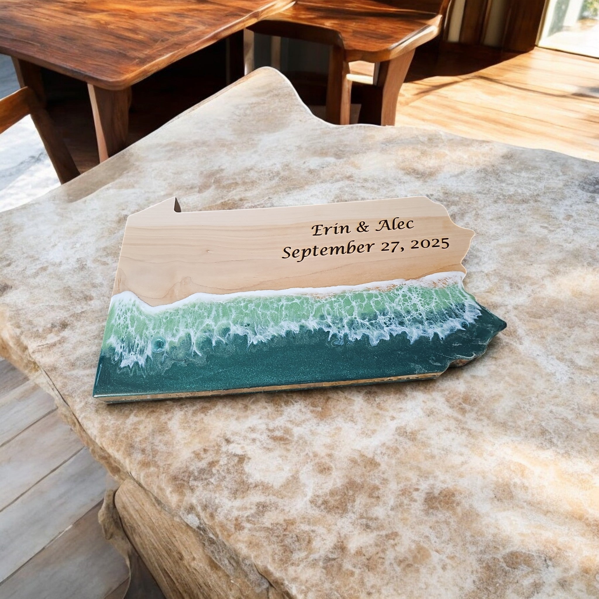 Custom engraved teal ocean wave resin charcuterie board on animal hide surface