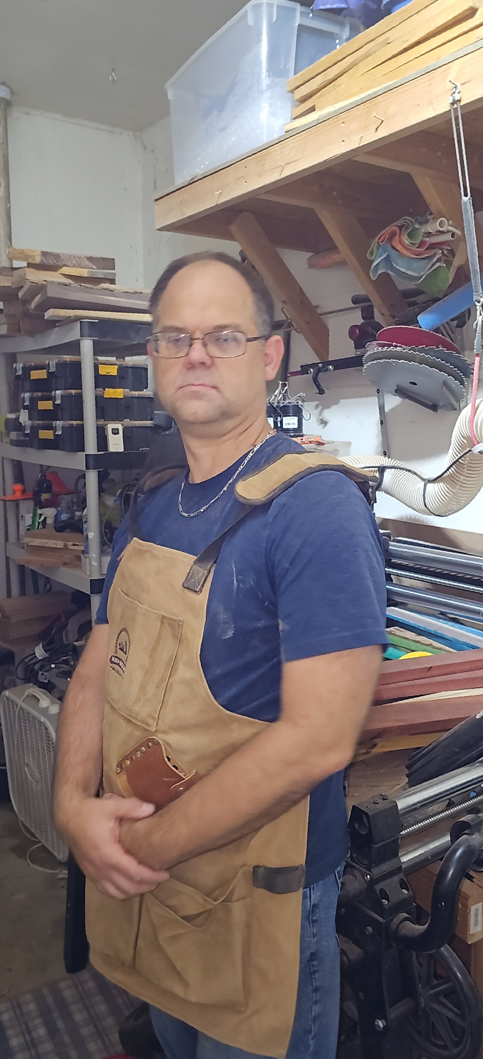 Dan from Creative Spruce Woodworking wearing a blue shirt and work apron.