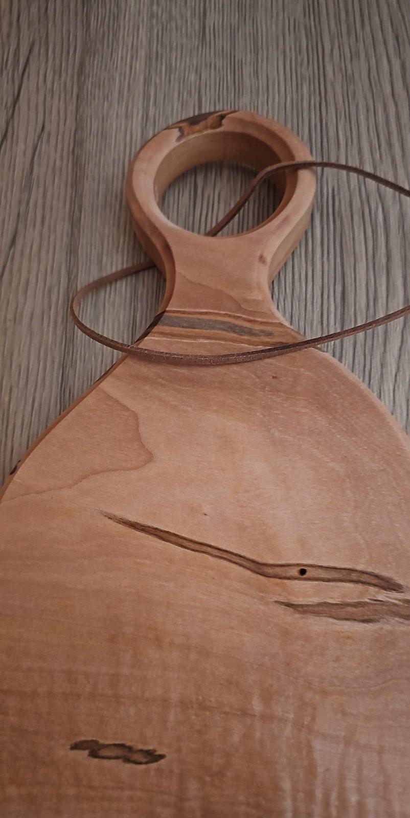 Asymmetrical wooden cutting board with brown leather loop handle