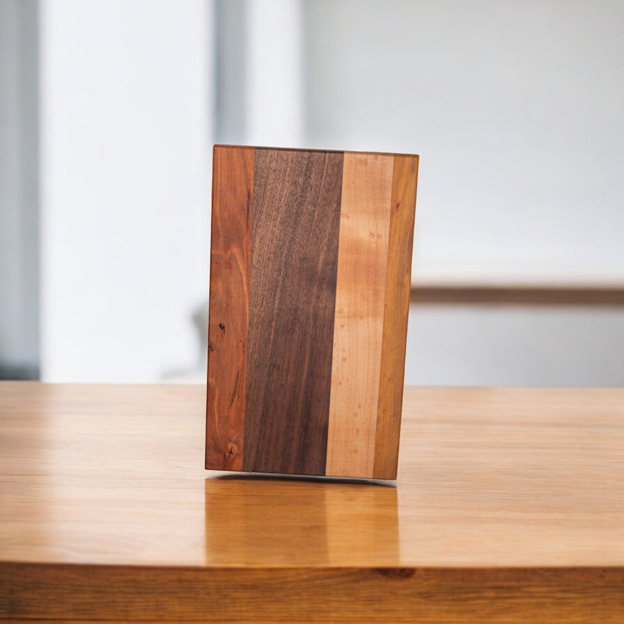 Walnut ash cherry wood cutting board on table