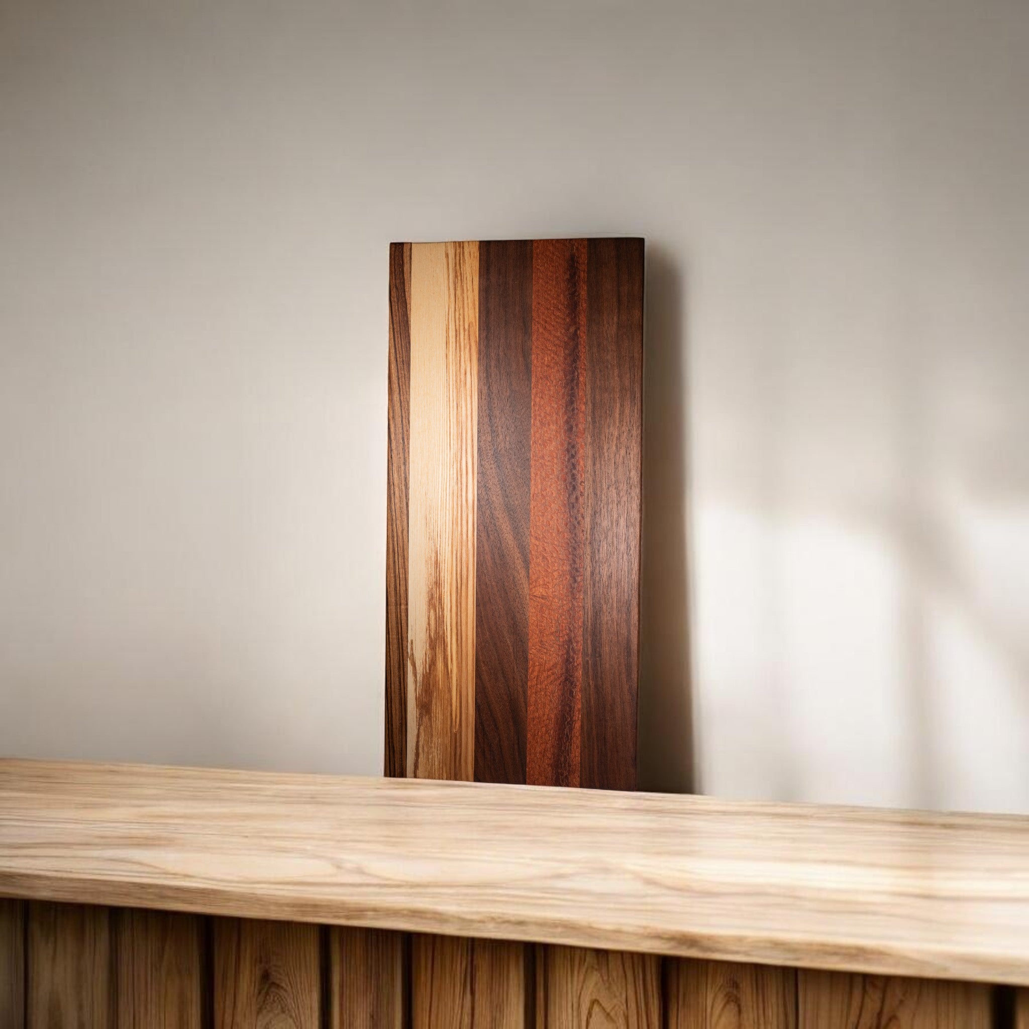 Handcrafted wooden cutting board with mixed wood strip design on counter