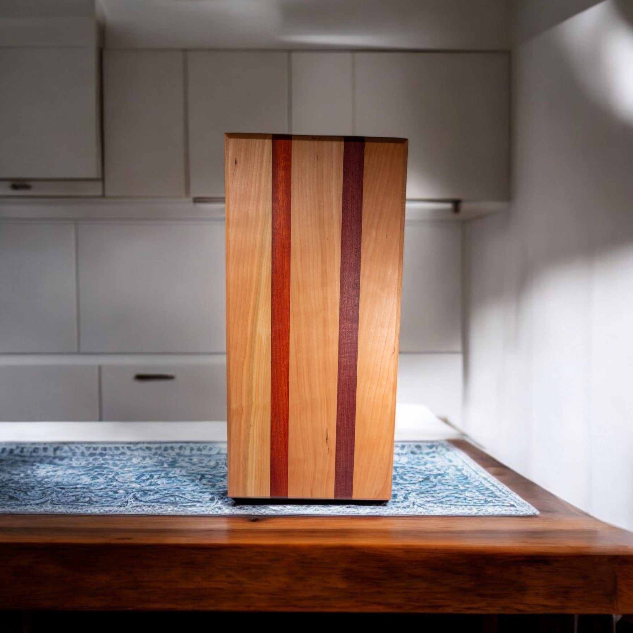 Cherry purpleheart padauk charcuterie board with vertical wood inlays on blue mat