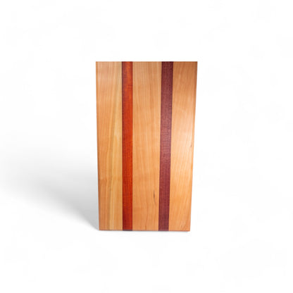 Cherry wood charcuterie board with orange-red padauk and deep purpleheart inlays