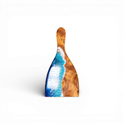 Close-up of oval olive wood charcuterie board showing textured blue resin wave detail