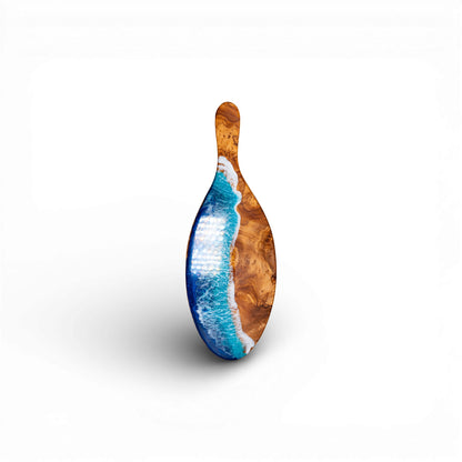 Oval olive wood serving platter featuring deep blue epoxy ocean wave design and handle