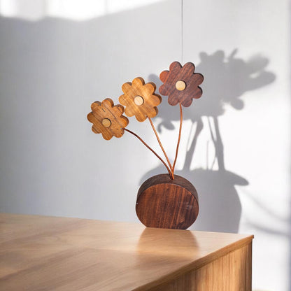 Wooden daisy flower decor on light wood surface with shadow