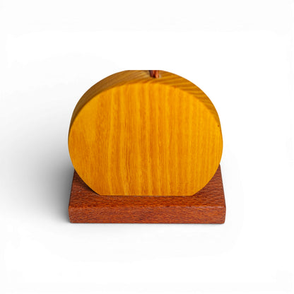 Detail shot of yellow wooden disc base with vertical grain and reddish-brown stand