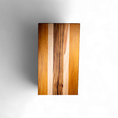 Four-strip hardwood serving board featuring zebra wood black stripes and maple