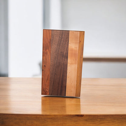 Walnut ash cherry wood cutting board on table