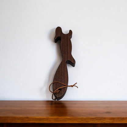 Upright dark walnut squirrel oven rack puller on wooden shelf
