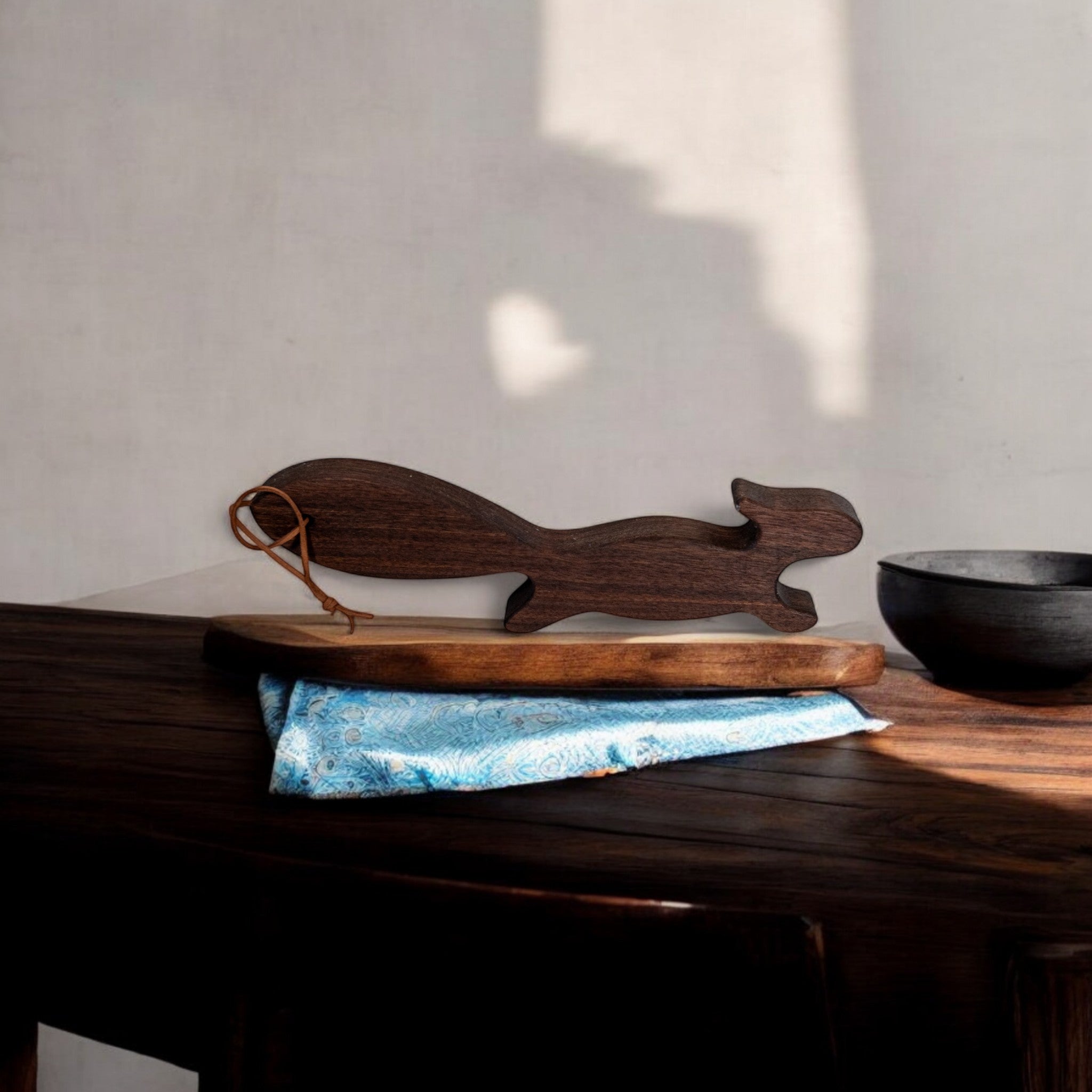 Dark walnut wooden squirrel oven rack puller with leather loop on display