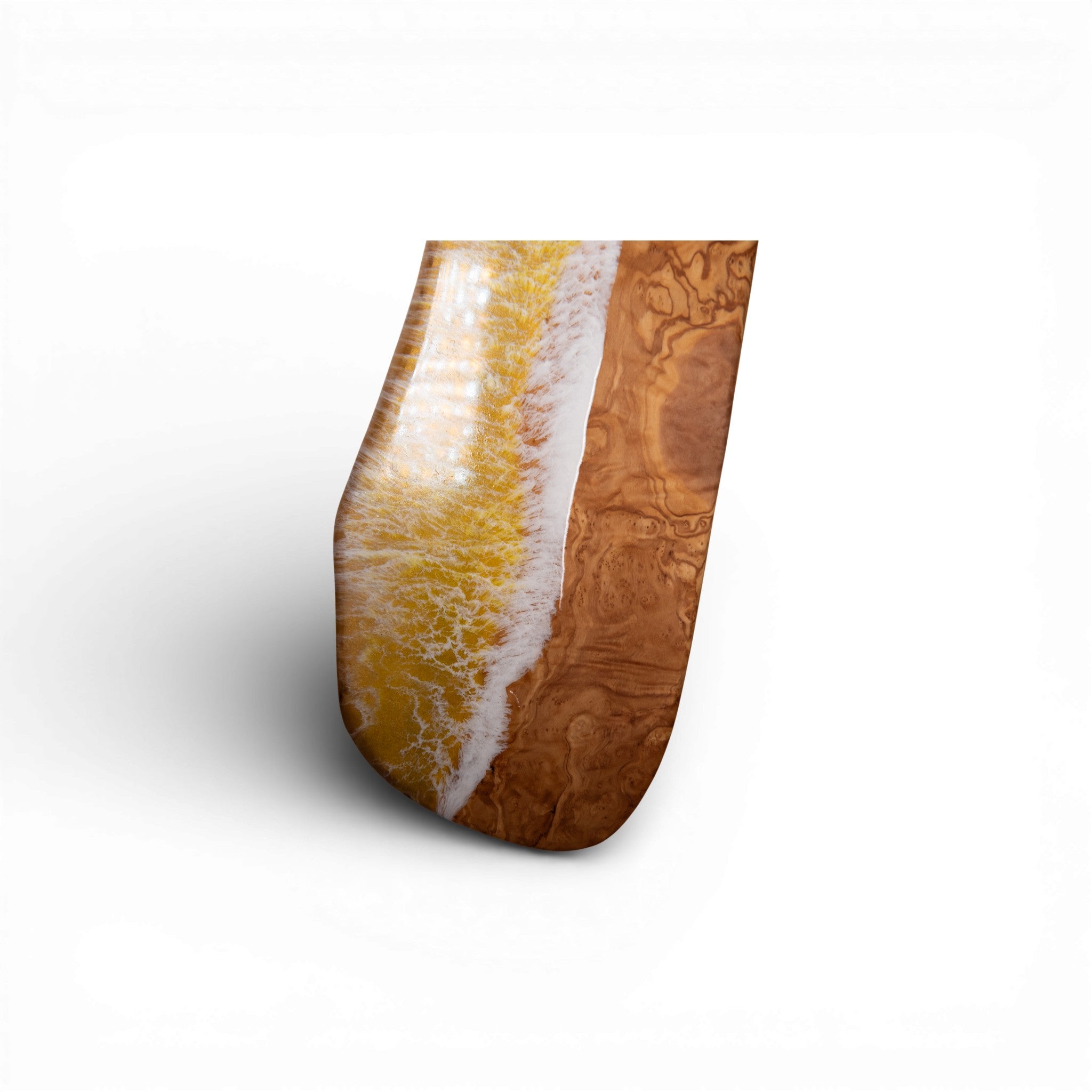 Angled view of yellow ocean wave resin charcuterie board with olive wood texture