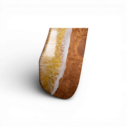 Angled view of yellow ocean wave resin charcuterie board with olive wood texture